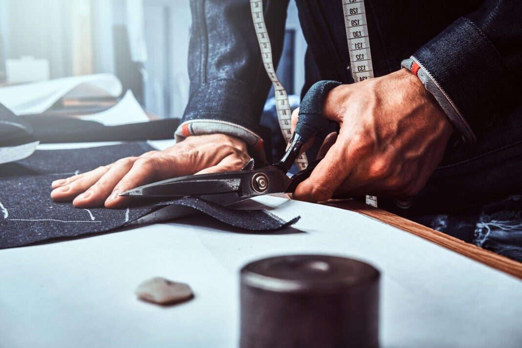 Tailor cutting cloth on a work table